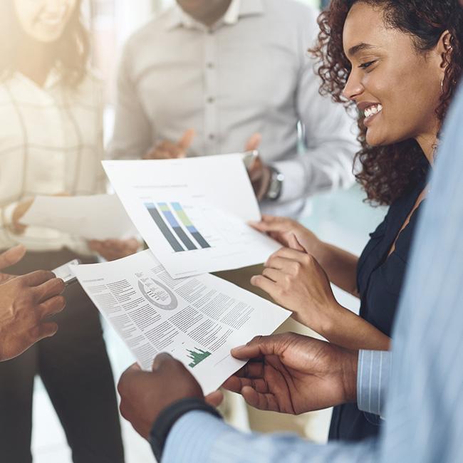A group of people looking at printed graphs